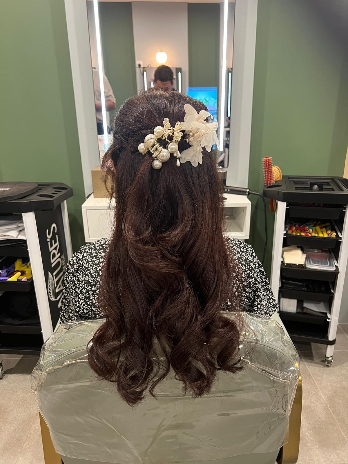A styled updo with a white floral hairpiece